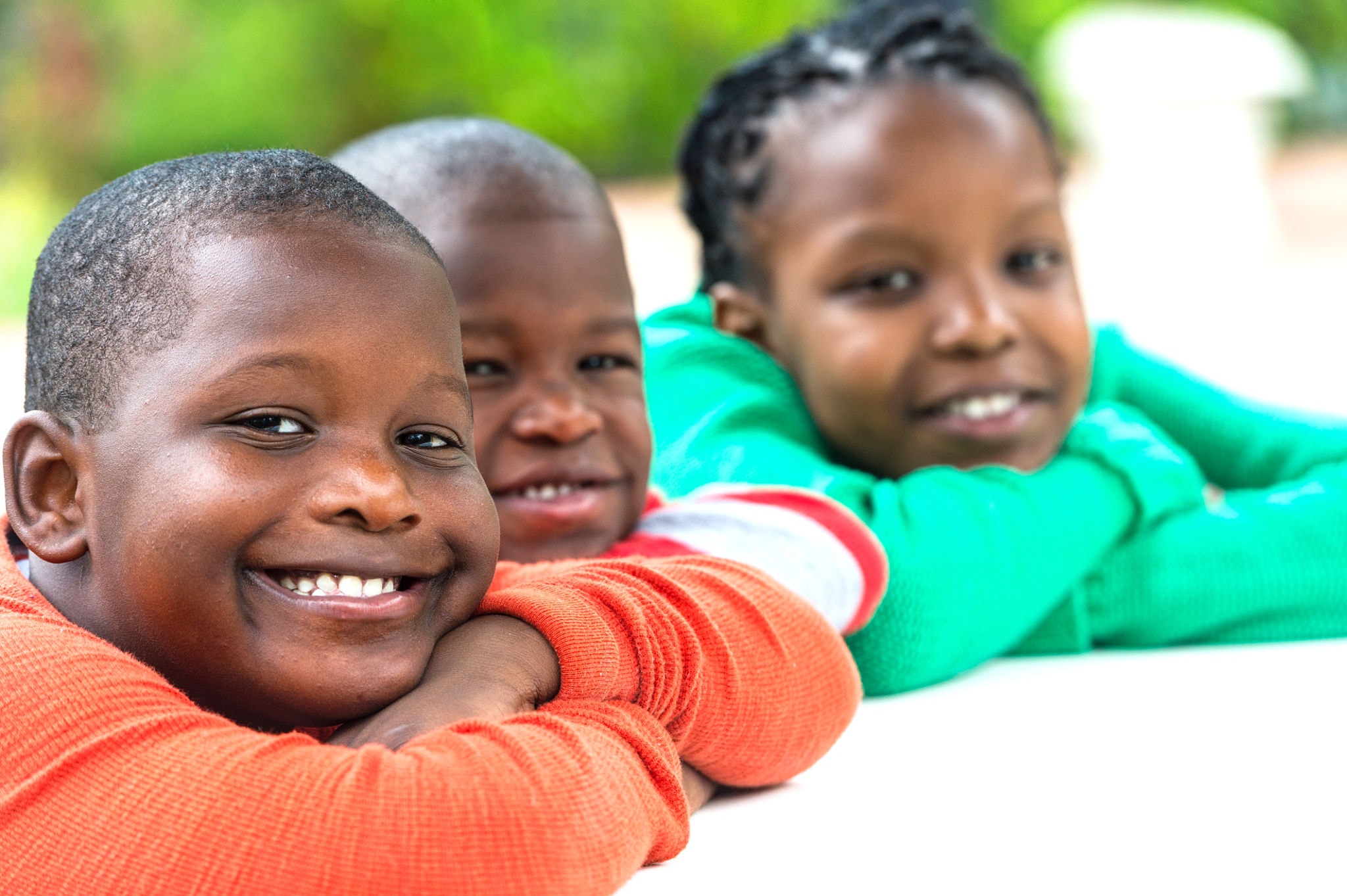 Three smiling children posing together
